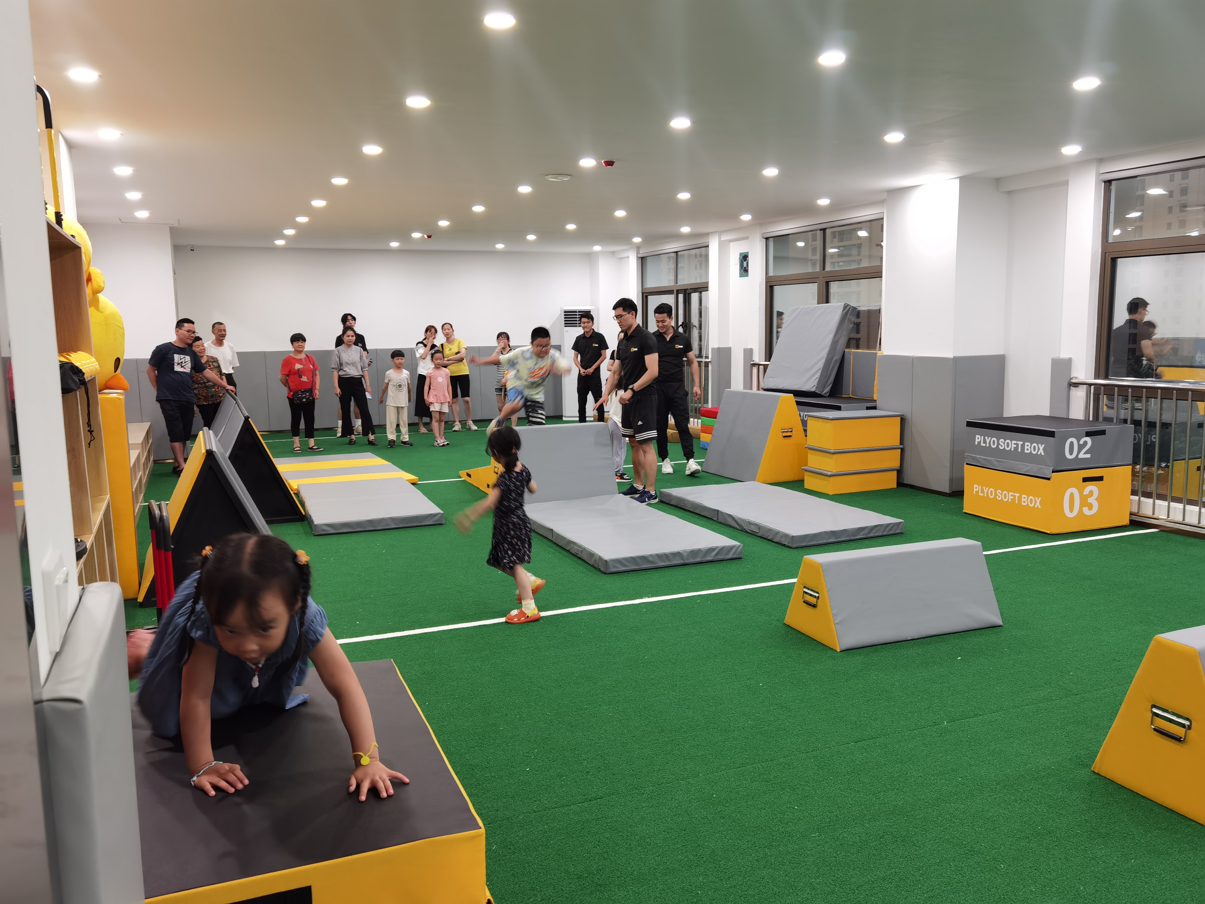 在体能教练的指导下正在体验运动乐趣的小朋友们