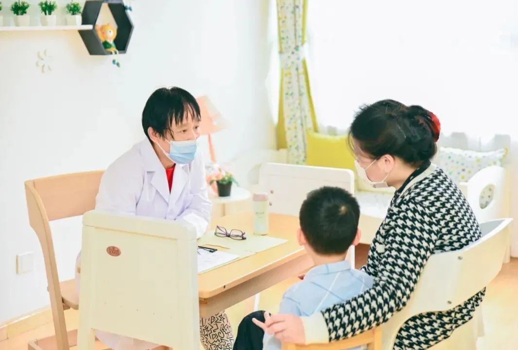 家长带着孩子正在和校医进行一对一的当天特需儿童特殊营养需求问诊;"