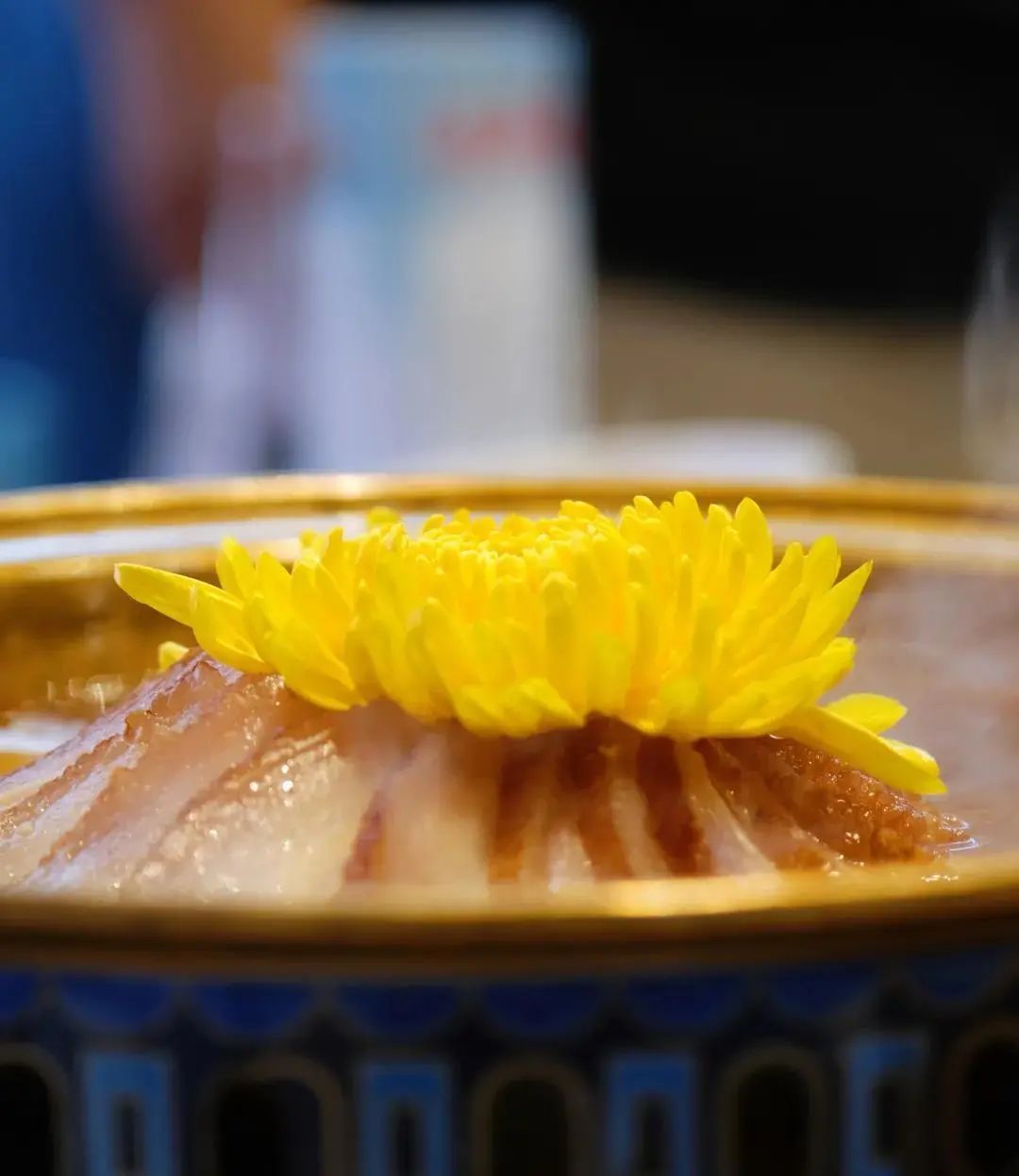 菊花暖锅以鲜鱼为汤头,锅内加入鸡汤煮沸,再取菊花瓣撕成茬丝洒入汤内