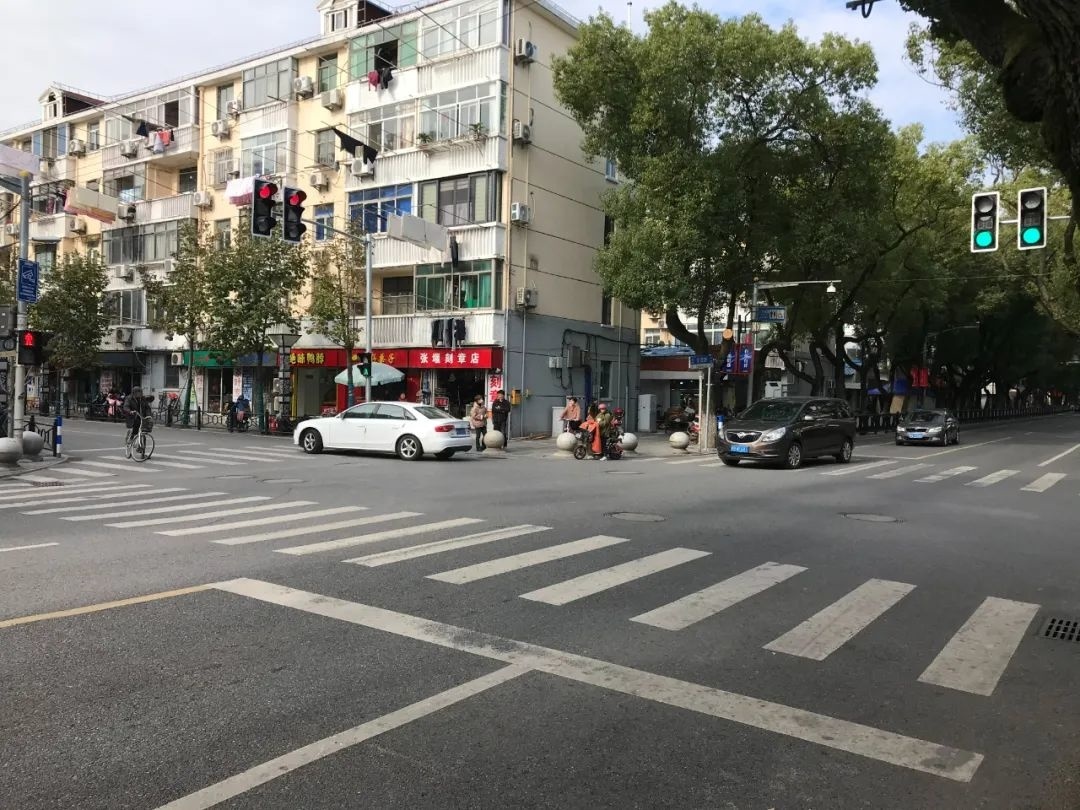 新华路路口看到,崭新的交通信号灯已经亮起,车辆和行人都在"红绿灯"的