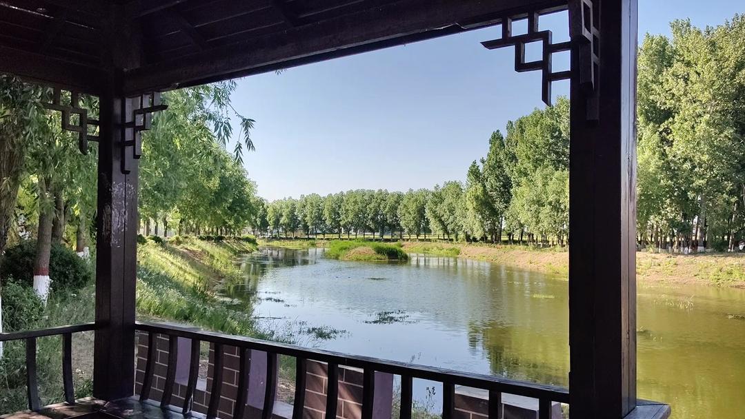 在苍翠树荫的笼罩下,涓涓河水流过大河桥,坐在河岸旁的凉亭下,自然