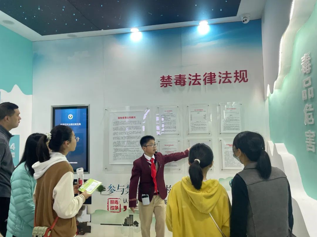 在北桥中学毒品预防教育馆内,六(2)班学生志愿者王昭程结合实物陈列