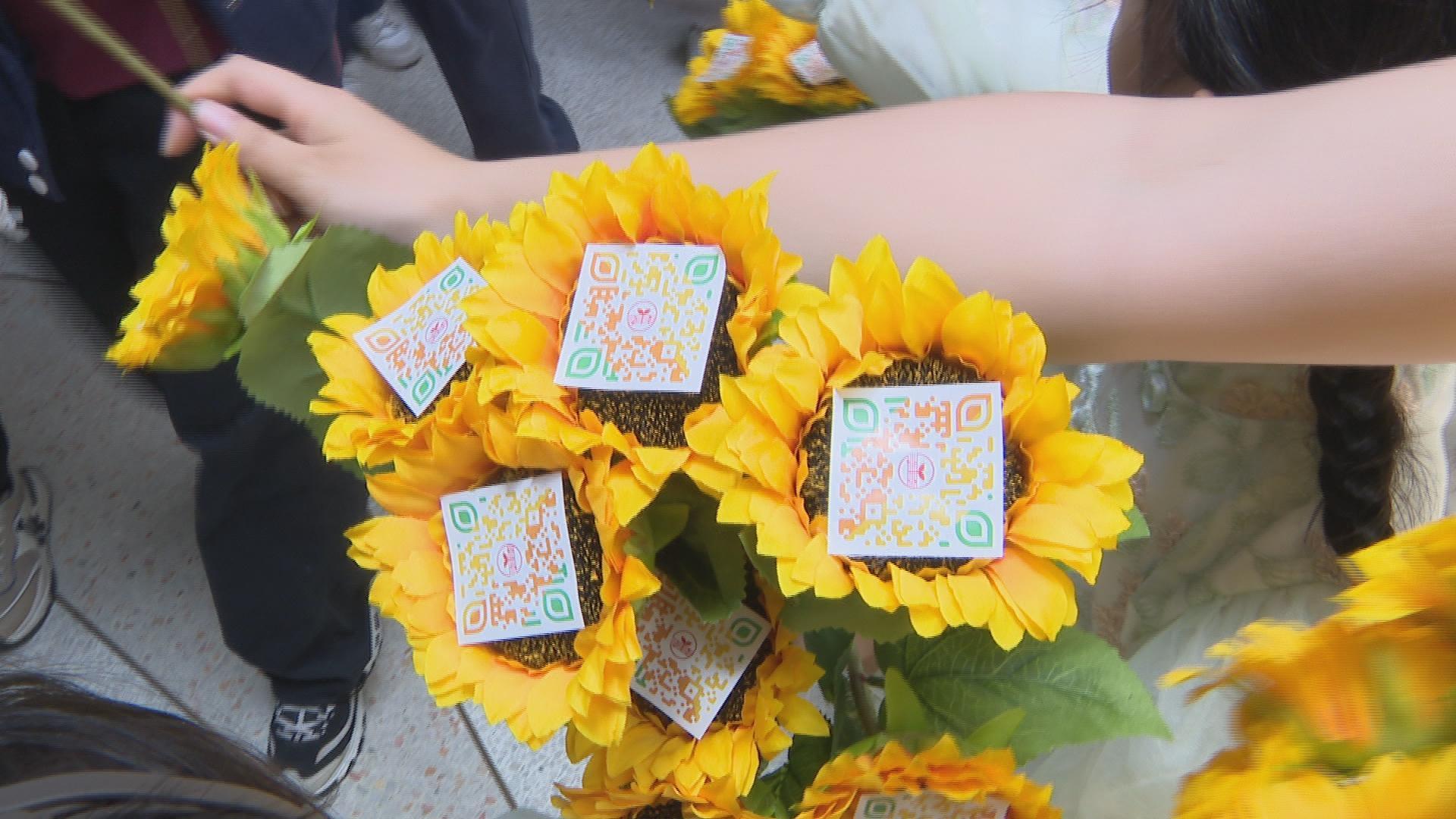 为了让祝福可以更长久一些,老师们制作了二维码贴纸,贴在一朵朵向日葵